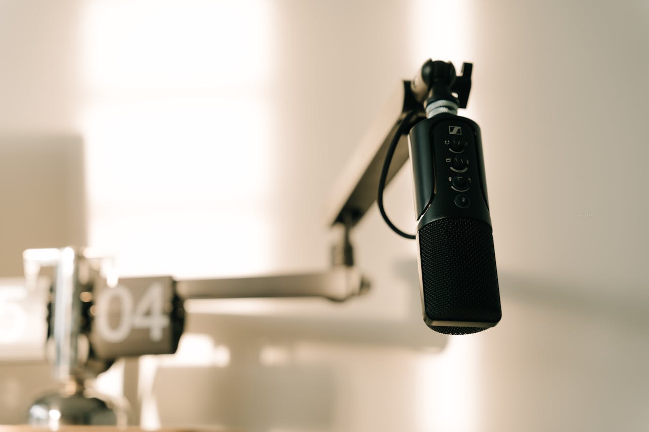 why-choose-us A sleek professional microphone on a boom arm in a minimalist studio.
